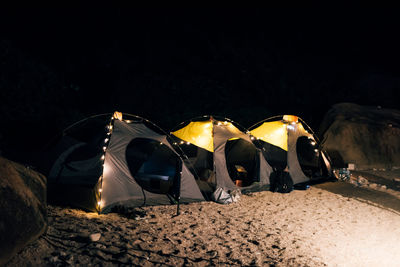 People standing on beach against sky at night