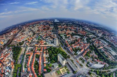 High angle view of city buildings against cloudy sky