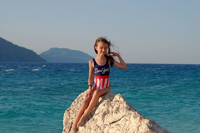 Girl in sea against clear sky