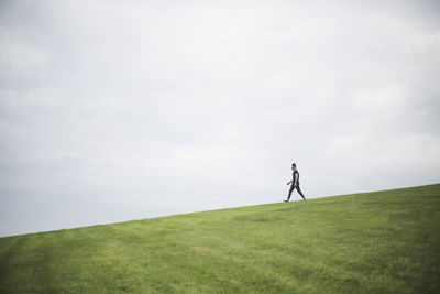 Man standing on field against sky