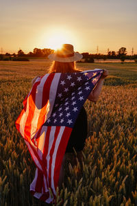 Rear view of woman holding american flag