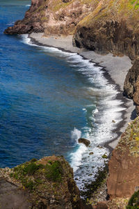 High angle view of rocks on sea shore