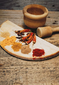 Spices by mortar and pestle on table