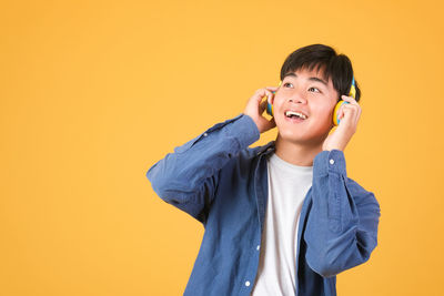 Portrait of a smiling boy against yellow background