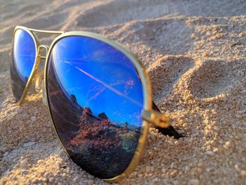 Close-up of sunglasses on sand at beach