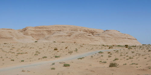 Scenic view of desert against clear blue sky