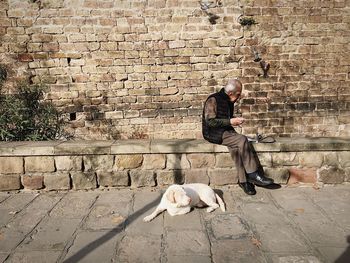 Man standing against brick wall