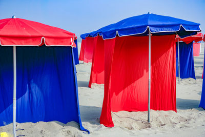 View of tent on beach against clear blue sky