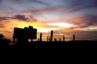 Silhouette built structures against sky during sunset