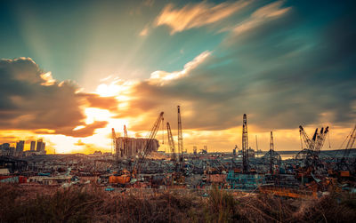 Illuminated cityscape against sky during sunset