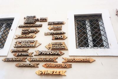 Low angle view of directional signs mounted on house wall