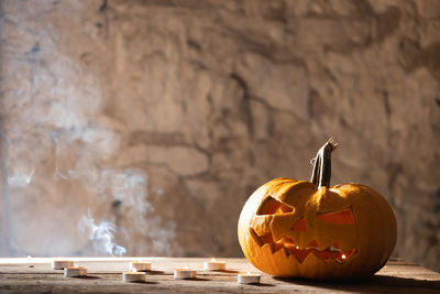 Close-up of pumpkin on table against wall