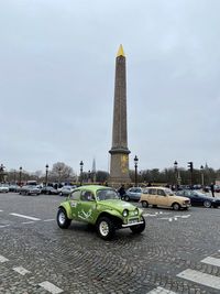 Cars on road against sky in city