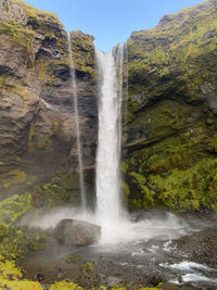 Scenic view of waterfall in forest cliff mountain lake water island holiday travel sunny day nature 