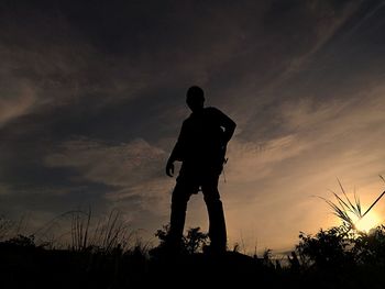 Low angle view of silhouette man standing against sky during sunset