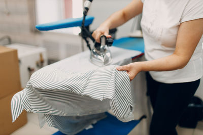 Midsection of man using sewing machine