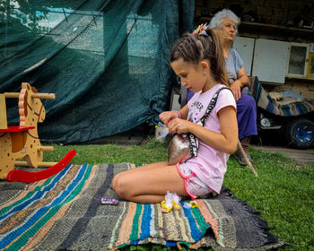 Side view of girl  sitting on field