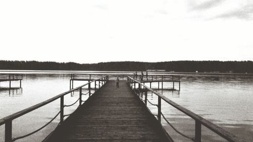 Pier over lake against clear sky