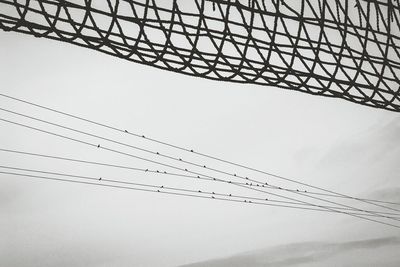 Low angle view of power lines against clear sky