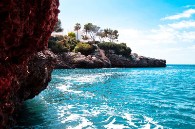 Rock formation in sea against sky