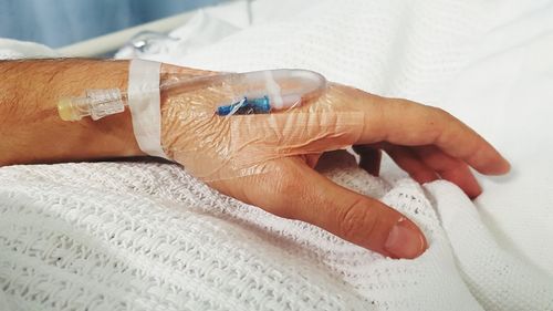 Close-up of hands on bed