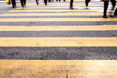 Low section of people walking on zebra crossing