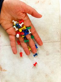 High angle view of hand holding multi colored pencils