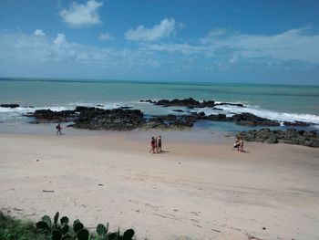 People on beach against sky