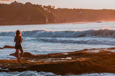 Woman standing on beach against sky