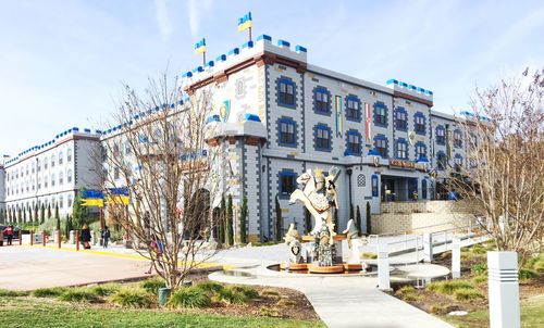 Statue by building in city against sky