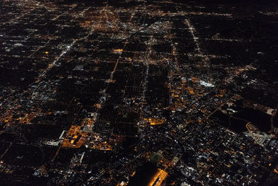 High angle view of city lit up at night