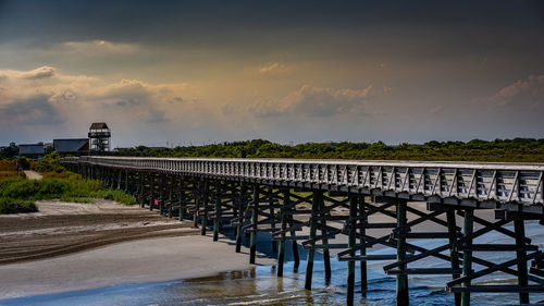 Bridge over river against sky during sunset