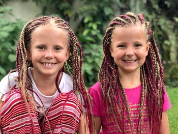 Portrait of smiling girls with dreadlocks at park