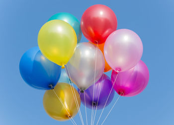 Low angle view of balloons against blue sky