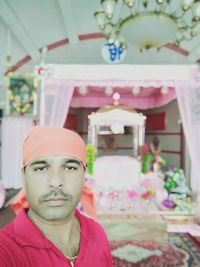 Portrait of man with pink flower at home
