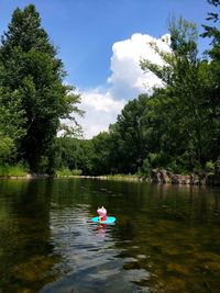 People floating on lake against sky