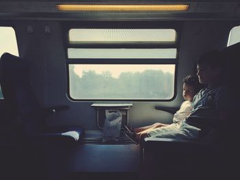 Rear view of people sitting in train