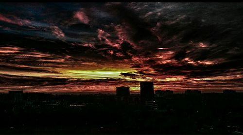 Buildings against cloudy sky at sunset