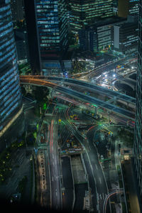 High angle view of illuminated bridges amidst buildings in city at night