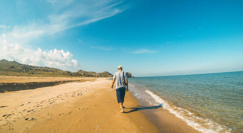 Man standing on beach against sky