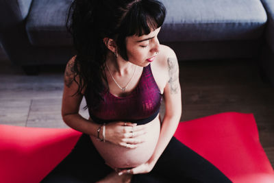 Pregnant woman exercising while sitting at home