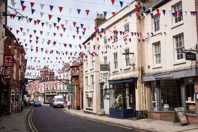 Buntings over road amidst buildings in city