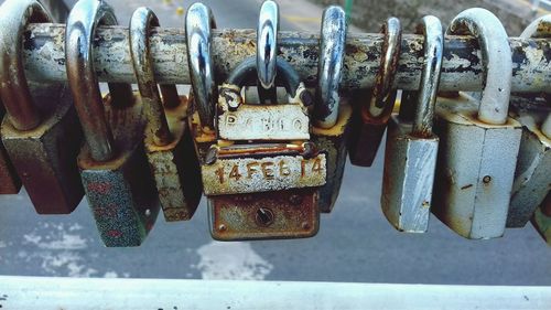 Close-up of padlocks hanging on rusty metal