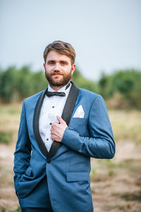 Portrait of young man standing on field