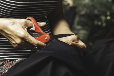 Midsection of woman cutting fabric