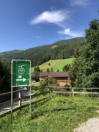 Information sign on field against sky