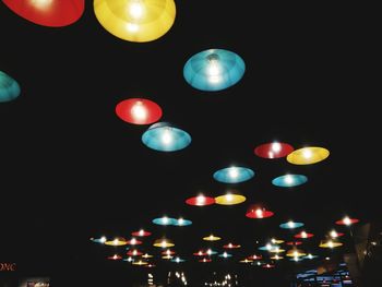 Low angle view of illuminated lights against sky at night