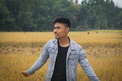 Portrait of young man standing on field