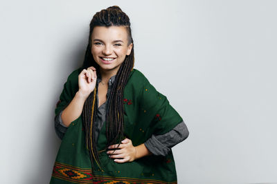 Portrait of young woman standing against white background