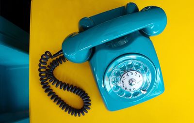 Close-up of blue retro telephone on table